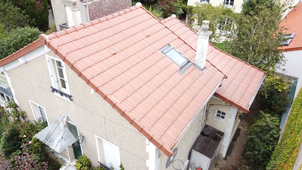 Couvreur du Compagnon de la Toiture inspectant la charpente dans les combles d'une meulière à Vulaines-sur-Seine